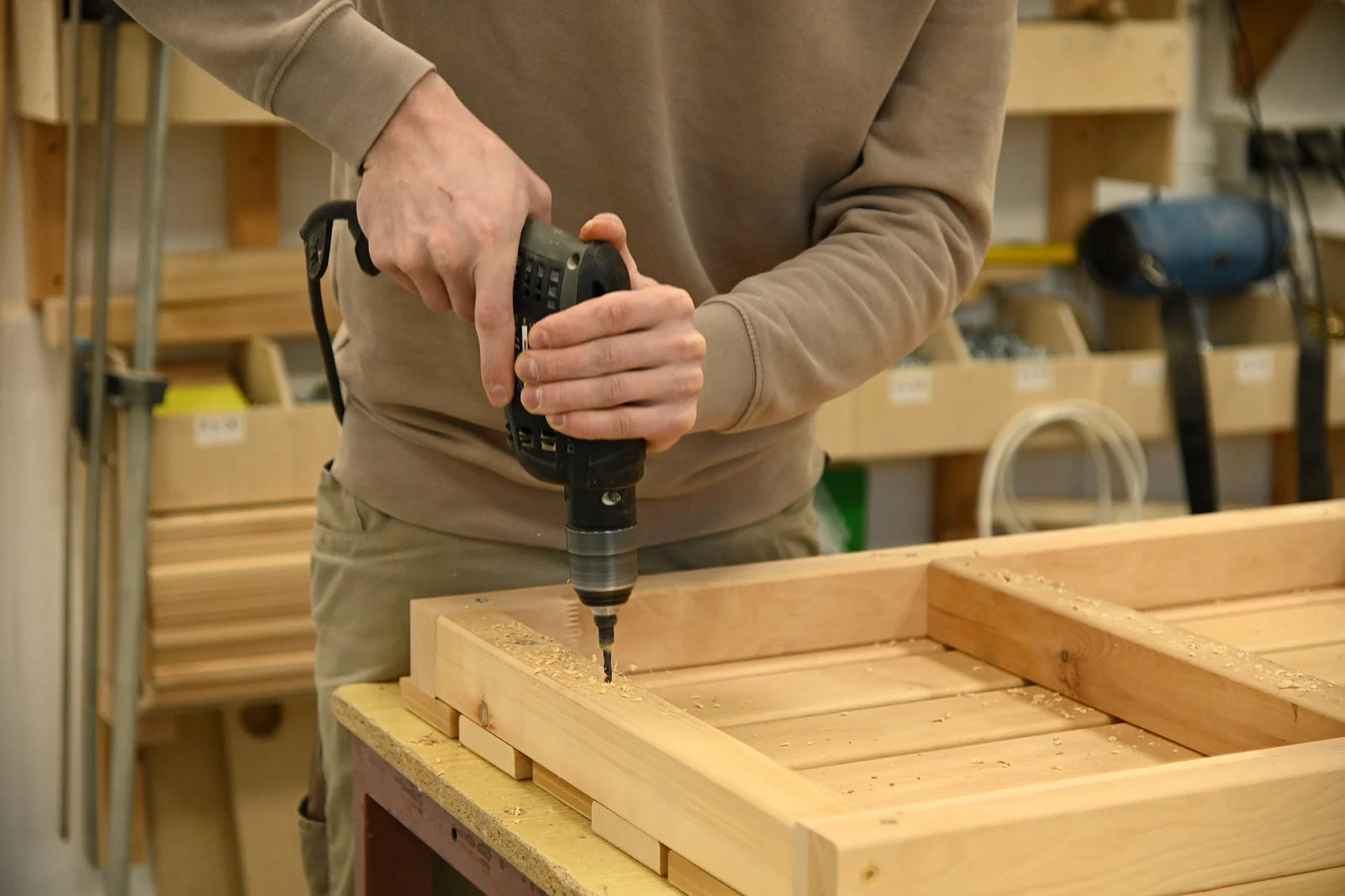 Monteur verschraubt einen Rahmen in der Werkstatt