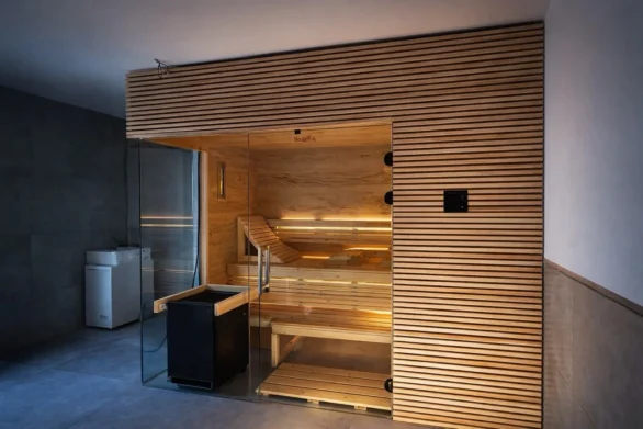 Sauna mit Glasfront vor einer dunklen Wand
