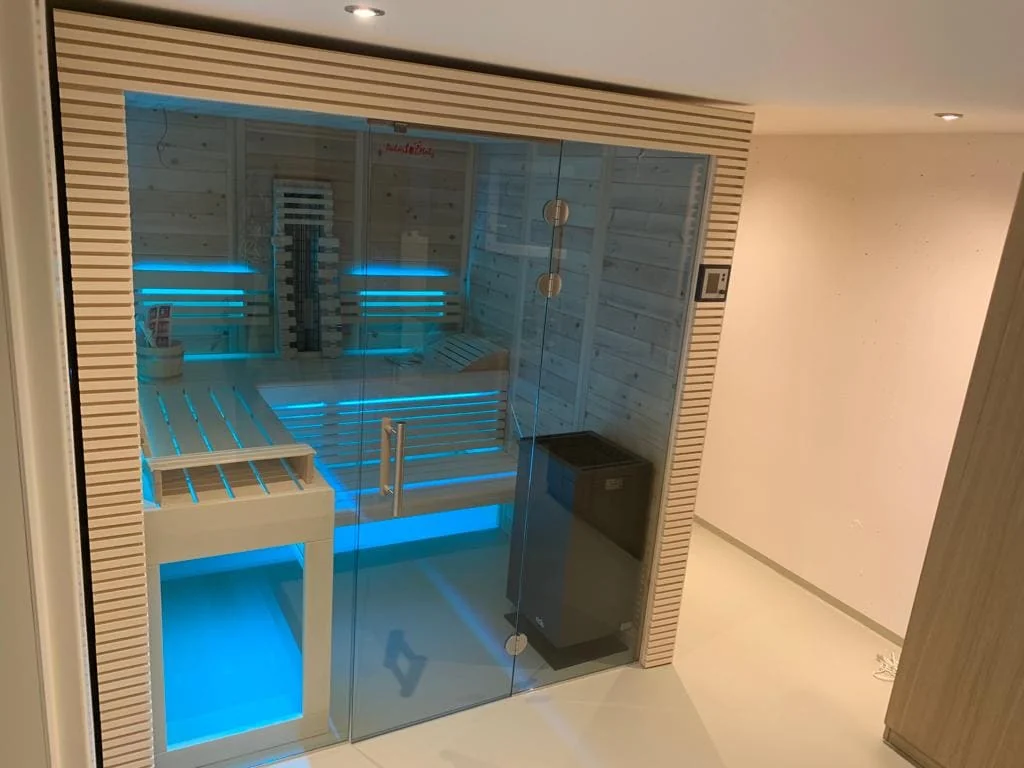 Sauna hinter einer Glasfront in einem hellen Raum