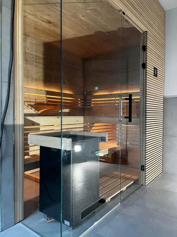 Sauna mit Glasfront und Ofen hinter der Scheibe